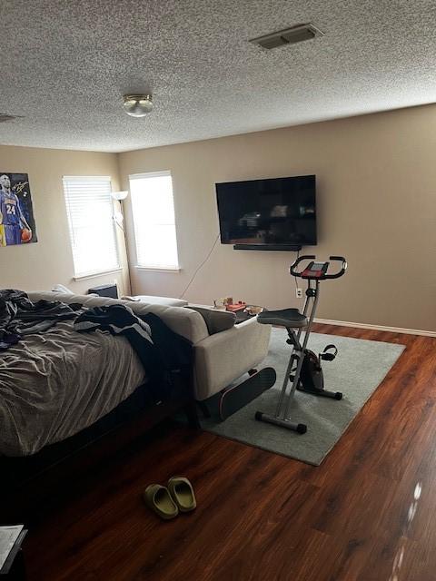 bedroom featuring hardwood / wood-style floors and a textured ceiling