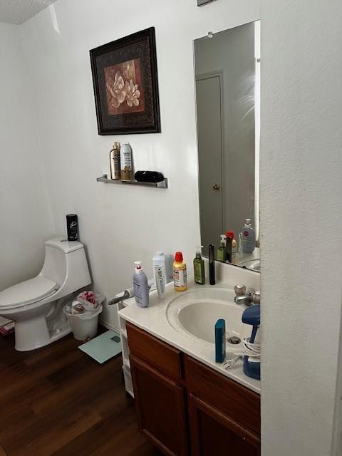 bathroom with hardwood / wood-style flooring, vanity, and toilet