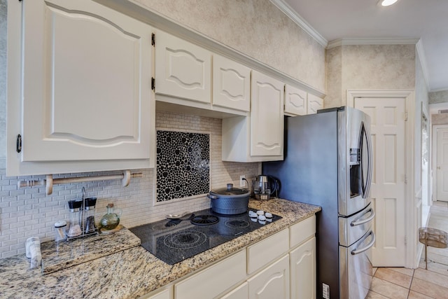 kitchen with white cabinetry, light stone counters, black electric cooktop, ornamental molding, and backsplash