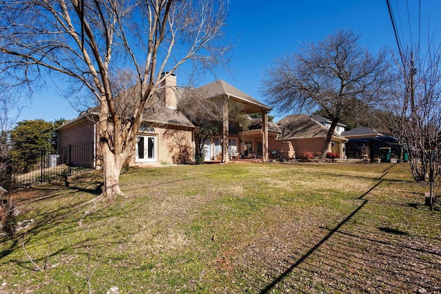 back of property featuring french doors and a lawn