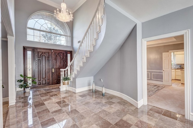 entrance foyer featuring a high ceiling, ornamental molding, and an inviting chandelier