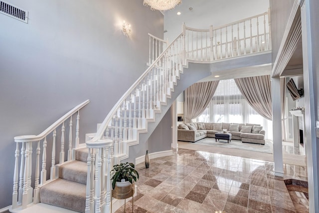 stairway featuring a towering ceiling