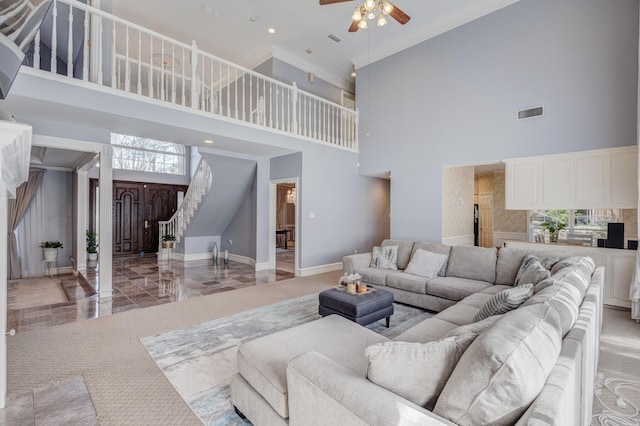 living room featuring ceiling fan and a high ceiling