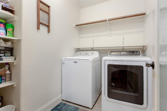 laundry area featuring light tile patterned floors and washer and dryer