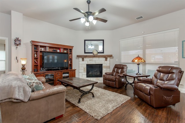 living room featuring ceiling fan, dark wood-type flooring, and a fireplace