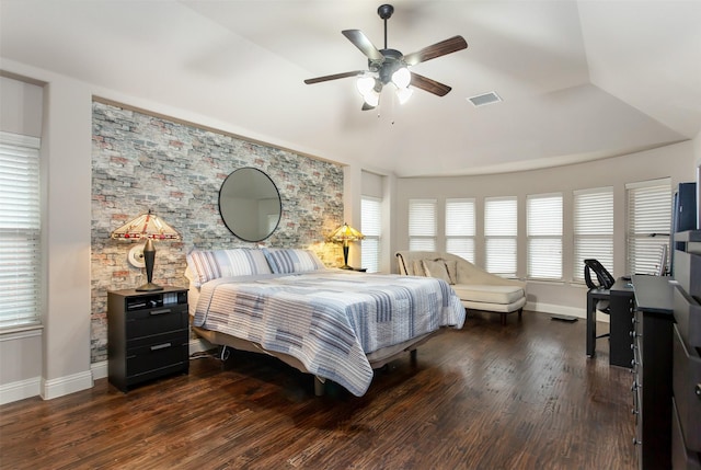 bedroom featuring multiple windows, vaulted ceiling, dark wood-type flooring, and ceiling fan