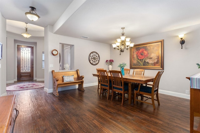 dining area featuring dark wood-type flooring and a notable chandelier