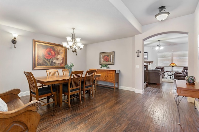 dining space with dark hardwood / wood-style flooring and ceiling fan with notable chandelier