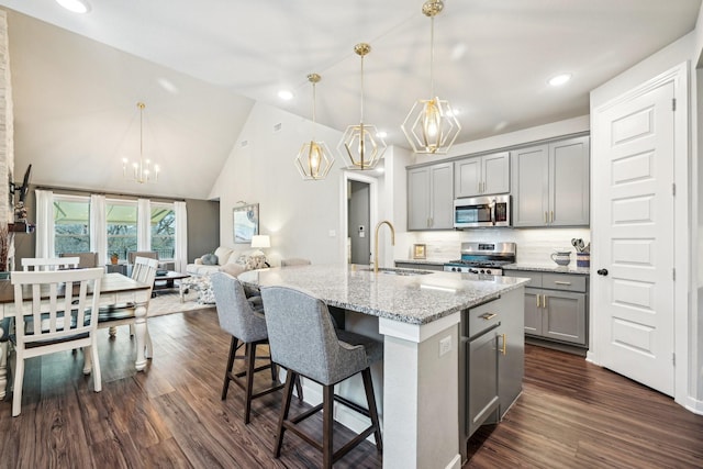 kitchen featuring sink, gray cabinetry, decorative light fixtures, an island with sink, and stainless steel appliances