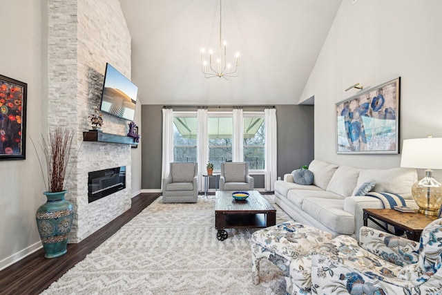 living room with dark hardwood / wood-style flooring, high vaulted ceiling, a chandelier, and a fireplace