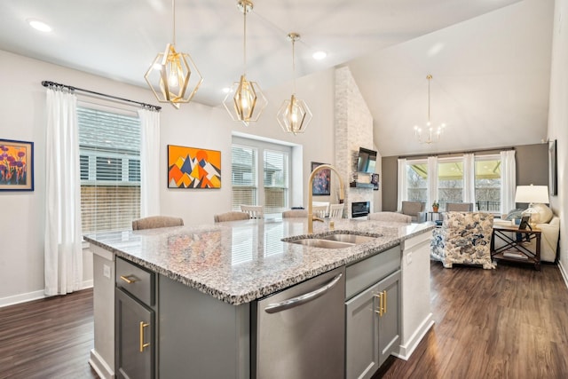 kitchen with dishwasher, sink, gray cabinetry, and a kitchen island with sink