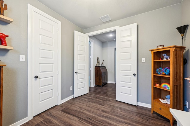 bedroom with dark hardwood / wood-style flooring