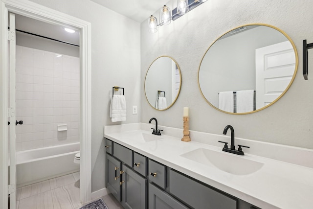 full bathroom with vanity, toilet, and tiled shower / bath combo