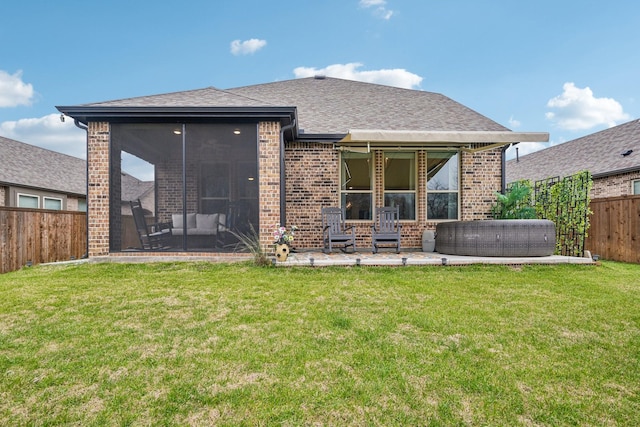 rear view of house featuring a lawn, a sunroom, and a patio