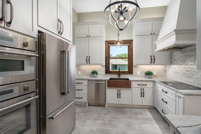 kitchen featuring white cabinetry, hanging light fixtures, custom exhaust hood, and stainless steel appliances