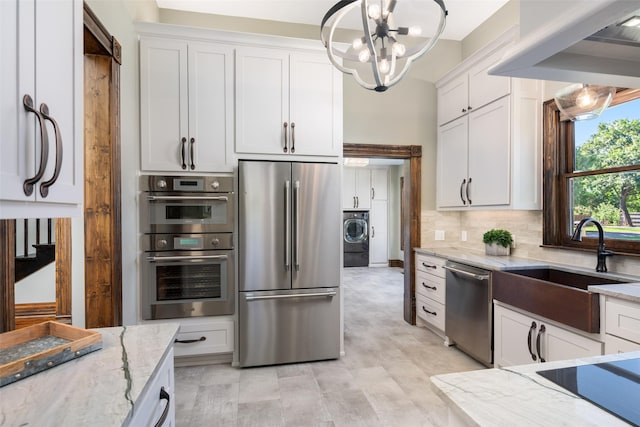 kitchen featuring sink, white cabinetry, pendant lighting, stainless steel appliances, and light stone countertops