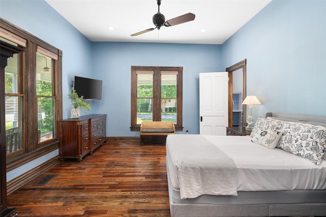 bedroom with multiple windows, dark wood-type flooring, and ceiling fan