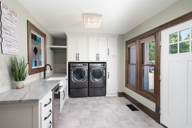 laundry room featuring cabinets, sink, and washing machine and clothes dryer