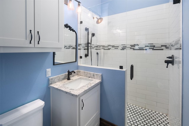 bathroom featuring vanity, toilet, and a shower with door