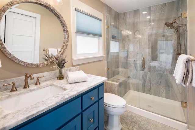 bathroom with a shower with door, vanity, and toilet