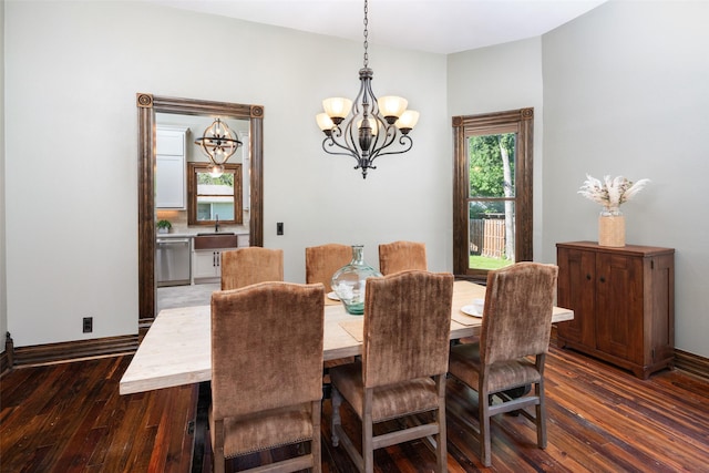 dining space with dark wood-type flooring, a chandelier, and sink