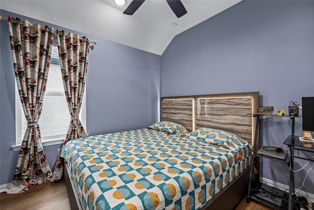 bedroom with ceiling fan, lofted ceiling, and wood-type flooring