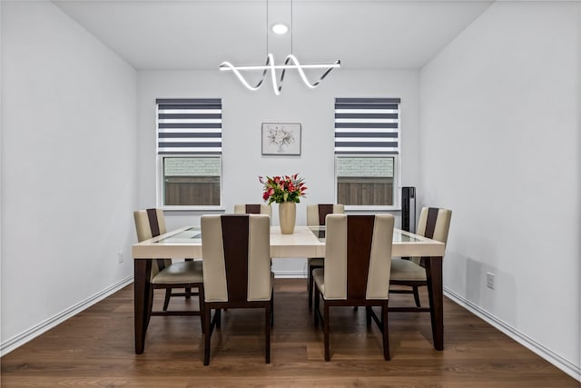 dining area featuring dark wood-type flooring, a wealth of natural light, and a chandelier