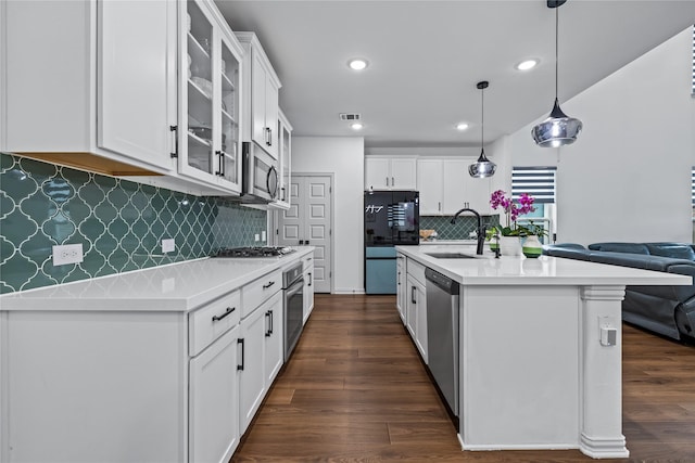 kitchen with stainless steel appliances, white cabinetry, sink, and pendant lighting