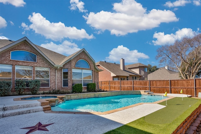 view of swimming pool with an in ground hot tub