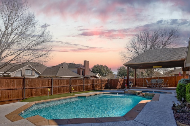 pool at dusk featuring a patio