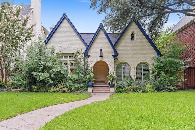 english style home featuring a front lawn