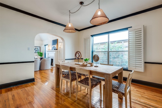 dining area with crown molding and light hardwood / wood-style floors