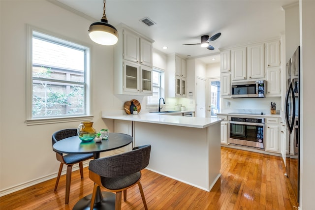 kitchen featuring white cabinetry, light hardwood / wood-style floors, black appliances, and kitchen peninsula