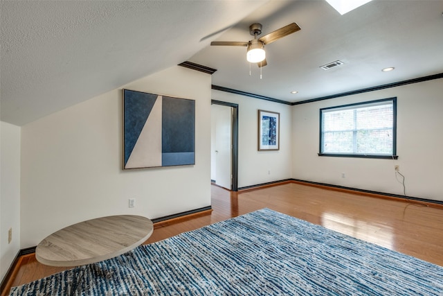 bedroom with crown molding, light hardwood / wood-style floors, ceiling fan, and a textured ceiling