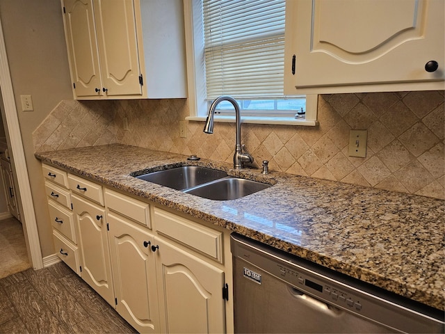 kitchen featuring dishwasher, sink, light stone countertops, and backsplash