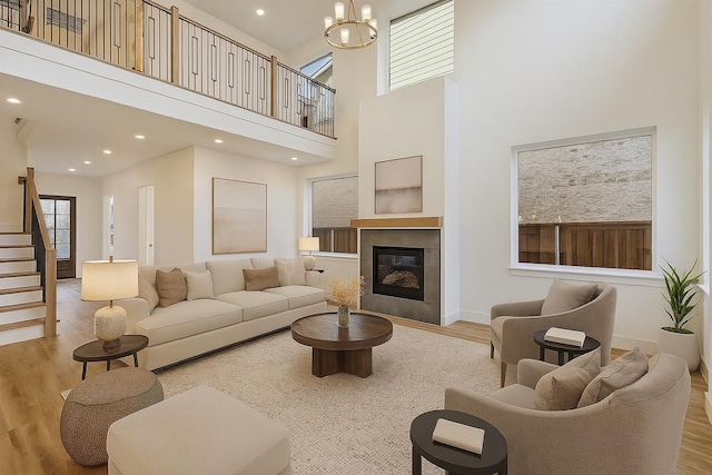 3703 Pilgrims Mews, Rowlett, TX 75088 - living room featuring wood finished floors, a towering ceiling, recessed lighting, a tiled fireplace, and stairs