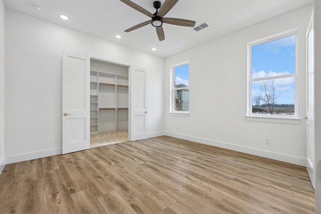 3703 Pilgrims Mews, Rowlett, TX 75088 - unfurnished bedroom with light wood-style floors, a spacious closet, recessed lighting, a ceiling fan, and a closet