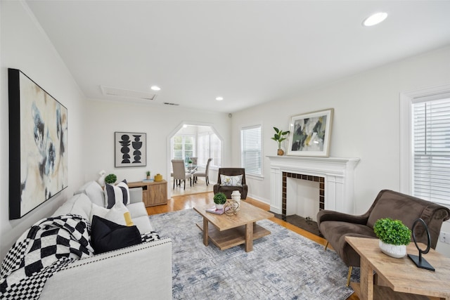 living room with a tile fireplace and light hardwood / wood-style floors