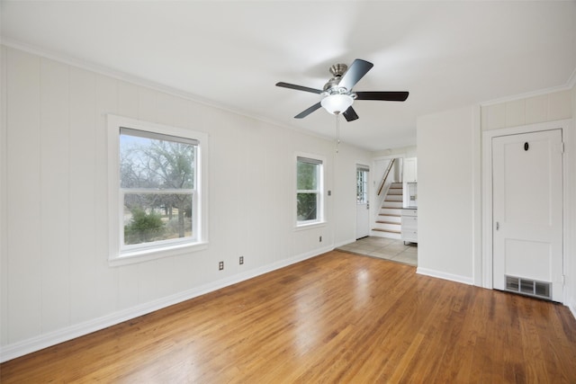 spare room with hardwood / wood-style floors, crown molding, and ceiling fan