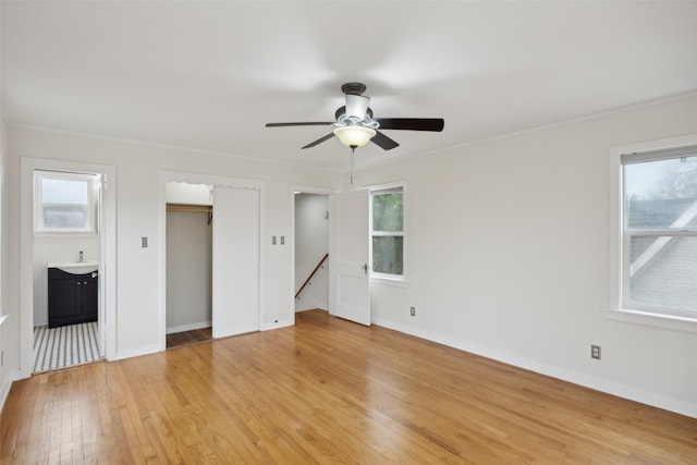 unfurnished bedroom featuring ensuite bathroom, sink, crown molding, and light hardwood / wood-style flooring