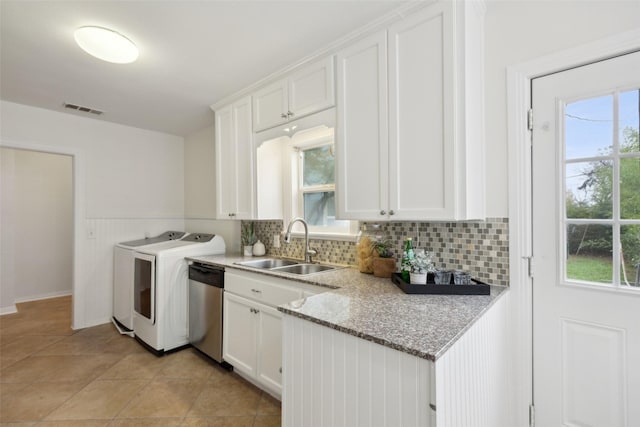 kitchen with white cabinetry, sink, stainless steel dishwasher, light stone counters, and independent washer and dryer