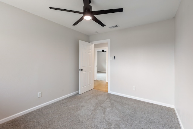 spare room with ceiling fan and light carpet