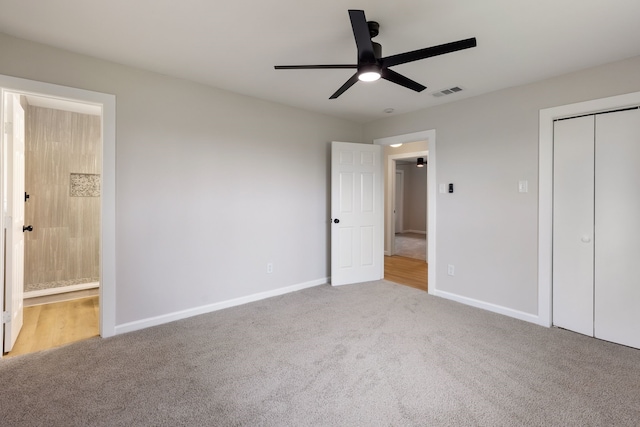 unfurnished bedroom with ceiling fan, carpet, ensuite bath, and a closet