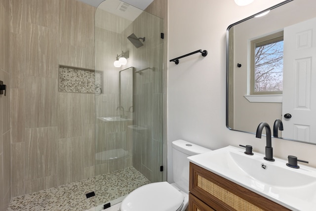 bathroom featuring vanity, an enclosed shower, and toilet