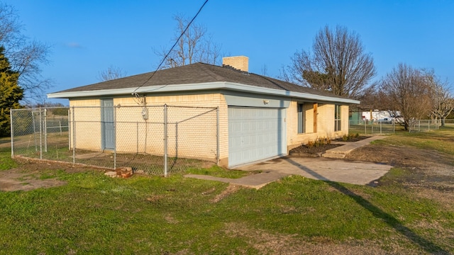 view of property exterior with a garage, a yard, and an outbuilding