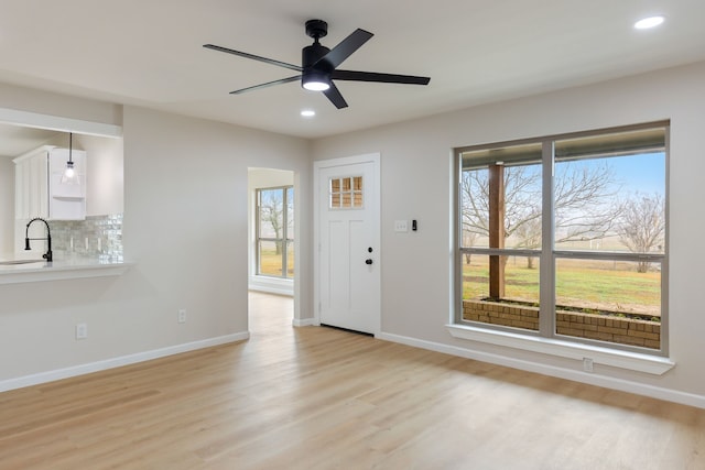 entryway featuring ceiling fan, sink, and light hardwood / wood-style floors