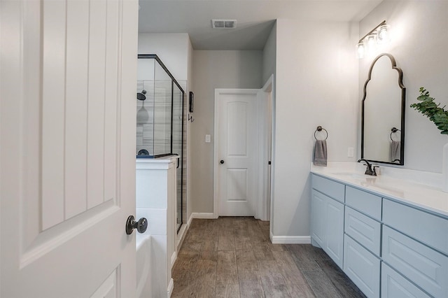 bathroom featuring a shower with door, vanity, and hardwood / wood-style floors