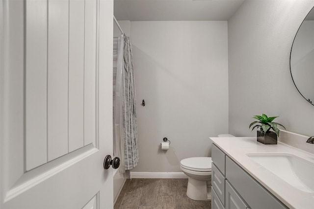 bathroom with vanity, hardwood / wood-style floors, curtained shower, and toilet