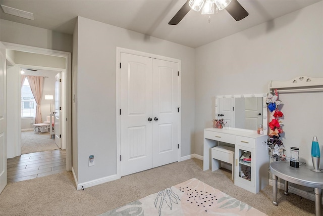 carpeted bedroom featuring ceiling fan and a closet