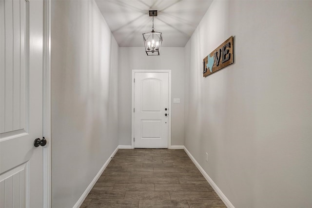 doorway with dark hardwood / wood-style floors and a chandelier